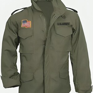 May include: Olive green military-style jacket with a high collar and multiple pockets. Features an American flag patch and a "U.S. ARMY" patch. The jacket has a zipper closure and buttoned cuffs.