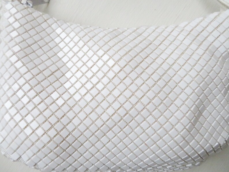 May include: A white mesh handbag with a square pattern.