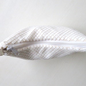 May include: White mesh purse with a zipper closure and a white strap.