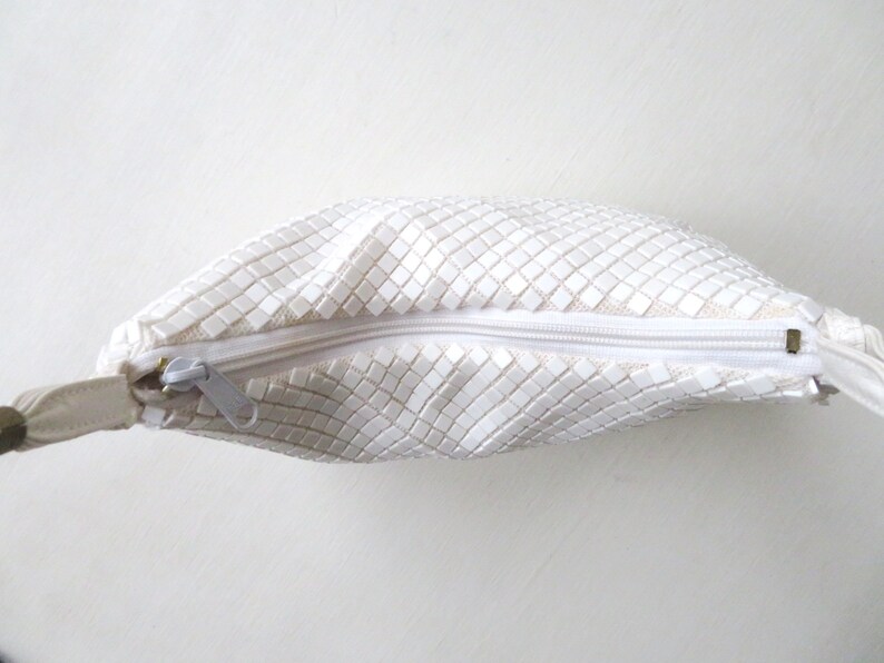 May include: White mesh purse with a zipper closure and a white strap.