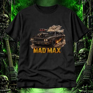May include: A black short-sleeved t-shirt featuring a graphic of a dark, weathered muscle car with a large engine protruding from the bonnet, surrounded by dust and flames. The text MAD MAX is printed in bold, distressed yellow letters below the car.