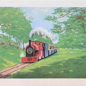 May include: A vintage illustration of a red steam train with a smiling face, pulling blue passenger carriages through a green landscape. White smoke billows from the train's smokestack, with trees lining the tracks.