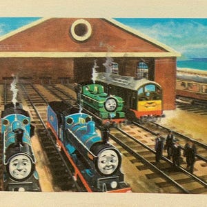 May include: A colourful illustration of cartoon trains in a train yard. The trains are blue, green, and yellow, with smiling faces. A brick building with a round window is in the background, with a blue sky and sea.