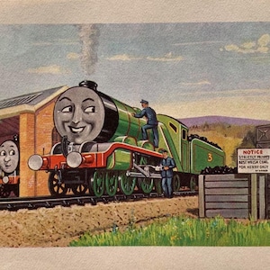 May include: Illustration of a green and red steam train with a smiling face, numbered 3. Two men in blue uniforms are on the train. Another train is in a train shed. A sign reads "NOTICE STRICTLY PRIVATE BEST WELSH COAL FOR HENRY ONLY".