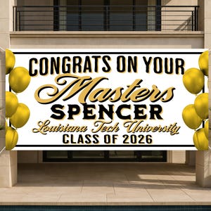 May include: A white banner with black and gold text that reads "CONGRATS ON YOUR Masters SPENCER Louisiana Tech University CLASS OF 2026". Gold balloons frame the banner. The banner is displayed on a building exterior.