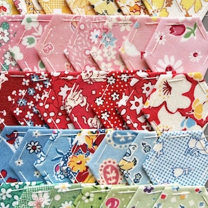 May include: Rows of colorful, hexagonal fabric pieces with floral and patterned designs. The fabrics feature a variety of colors, including yellow, pink, red, blue, and green. Each piece is stitched together, creating a patchwork effect, ideal for quilting or crafting projects.