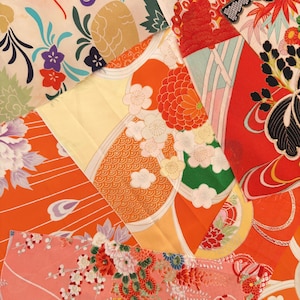 May include: A collection of patterned fabric pieces in a patchwork arrangement. The fabrics display a variety of designs, including flowers and geometric shapes, in vibrant colours such as orange, red, yellow, and pink, with touches of white, green, and purple.