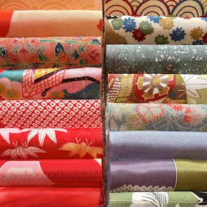 May include: A collection of rolled fabric bolts, showcasing a variety of patterns and colors. The fabrics feature floral, geometric, and abstract designs in shades of red, orange, blue, green, and purple. The textiles appear to be of high quality.