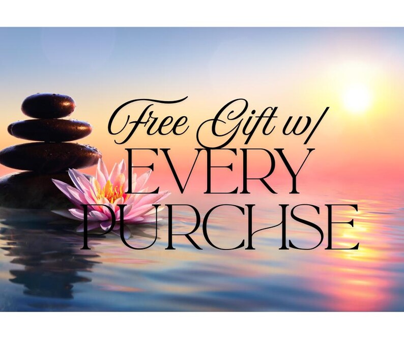 Puede incluir: Imagen serena con una pila de piedras oscuras, una flor de loto rosa y el texto "Free Gift w/ EVERY PURCHASE" sobre un fondo de puesta de sol sobre el agua. El agua refleja los colores del cielo.