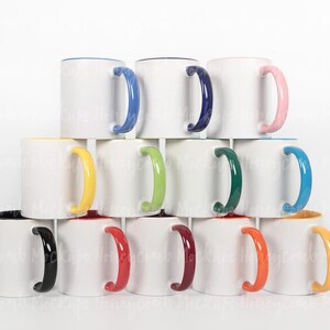 May include: A stack of white ceramic mugs with colored handles and rims. The mugs have handles in blue, pink, green, yellow, orange, black, and red. The rims are also colored, with some having a matching interior.