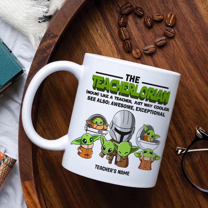 May include: White ceramic mug with the text "The Teacherlorian" and illustrations of a character. The mug also has the text "(Noun) Like a teacher, just way cooler. See also: Awesome, Exceptional" and "Teacher's Name".