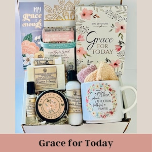 May include: A gift box filled with self-care items, including a mug with floral accents and the text "Be joyful in hope, patient in affliction, faithful in prayer." Other items include a devotional book, soap, lotion, and lip balm.