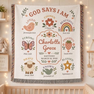 May include: Cream-coloured woven blanket with the text "GOD SAYS I AM" and various inspirational words and illustrations, including a bird, butterfly, rainbow, and a lamb. The name "Charlotte Grace" is featured prominently.
