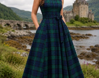 May include: A sleeveless floor-length dress featuring a dark green and navy blue plaid tartan pattern. The garment has a round neckline, a fitted bodice, and a waistline accented with a matching fabric tie belt. The skirt is full and pleated.