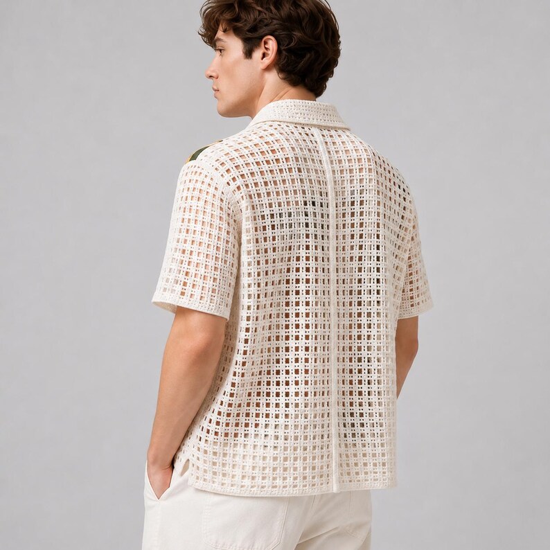 Pode incluir: Uma camisa de manga curta em tom branco sujo com um padr&atilde;o de croch&ecirc; aberto em forma de grade. A pe&ccedil;a possui um colarinho cl&aacute;ssico, uma costura vertical no centro das costas e uma bainha reta, exibindo uma constru&ccedil;&atilde;o texturizada semitransparente.