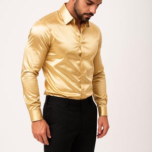 以下が含まれることがあります： ゴールドカラーのサテンシャツ。長袖でボタンダウン、黒いパンツと組み合わされています。シャツの生地は光沢があり滑らかな質感です。クラシックな襟とボタン付きのカフスが付いています。全体的に上品な印象です。