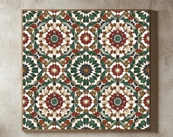 Op de afbeelding: Een ingelijste wandkunstprint met een herhalend geometrisch patroon in rood, groen en beige tinten. Het kunstwerk hangt boven een bed met wit beddengoed en een beige deken, wat een gezellige slaapkamer creëert.