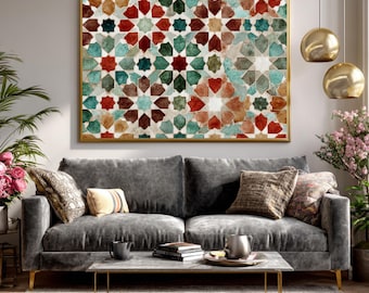 Op de afbeelding: Een ingelijst kunstwerk met een geometrisch patroon in tinten rood, groen, teal en bruin. Het kunstwerk, in een gouden lijst, hangt boven een grijze fluwelen bank. De kamer is ingericht met planten en gouden accenten.