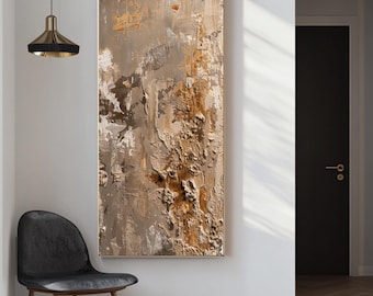 May include: Abstract textured wall art in a gold frame. The artwork features a palette of neutral colors, including shades of brown, beige, and white, with visible brushstrokes and a layered effect. The painting is displayed on a white wall.