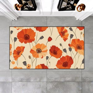 May include: Rectangular area rug featuring a floral pattern of orange poppies on a cream background. The rug has a black border and is placed on a tiled floor. The poppy flowers have dark brown centers and gray seed pods.
