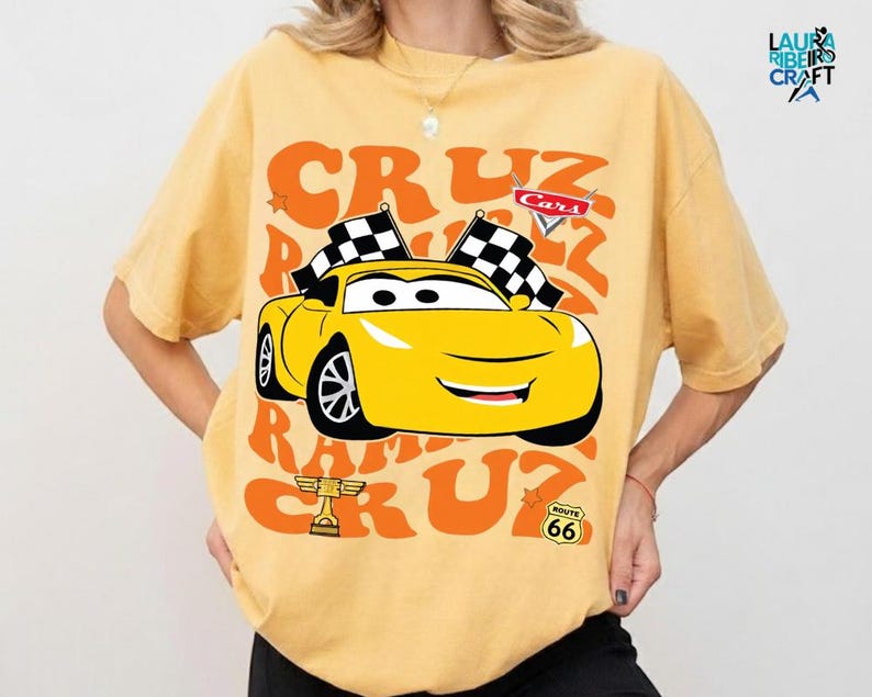 A yellow t-shirt with a graphic of a yellow race car and the text "CRUZ RUM CRUZ" printed on it.