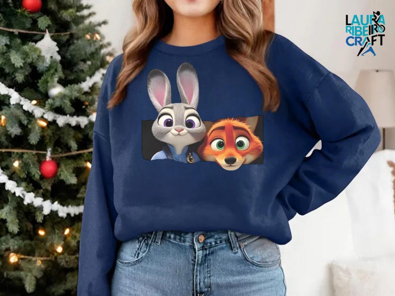 A woman wearing a blue sweatshirt with a graphic of a rabbit and a fox peeking out from the front pocket.