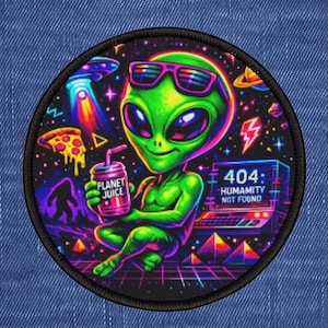 Op de afbeelding: Ronde patch met een groene alien met een zonnebril, die een Planet Juice-drank vasthoudt en voor een laptop zit met "404: Humanity Not Found". De achtergrond bevat een UFO, een pizzapunt en planeten, met een levendig, kleurrijk ontwerp.