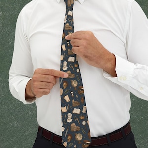 May include: A dark blue necktie featuring a repeating pattern of ancient Roman-themed illustrations, including the Colosseum, marble busts, helmets, globes, scrolls, books, swords, and hourglasses, printed in shades of beige, brown, and gold.