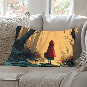 May include: Rectangular pillow featuring an illustration of a person in a red hooded cloak walking through a sunlit forest. The artwork has a warm color palette with shades of red, yellow, and brown. The person is carrying a black bag.