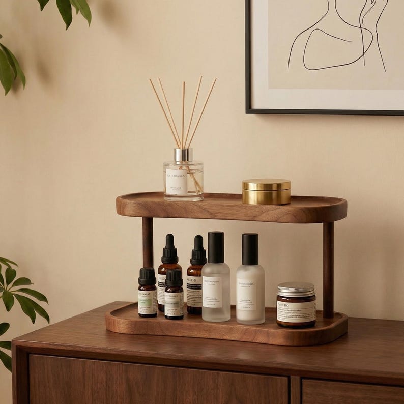 Peut inclure: Un plateau en bois &agrave; deux niveaux pr&eacute;sente divers produits d'aromath&eacute;rapie. L'&eacute;tag&egrave;re sup&eacute;rieure contient un diffuseur en verre avec des b&acirc;tonnets et une petite bo&icirc;te dor&eacute;e. L'&eacute;tag&egrave;re inf&eacute;rieure pr&eacute;sente des flacons d'huiles essentielles, des vaporisateurs et un pot avec un couvercle.