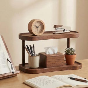 Peut inclure: Un organiseur de bureau en bois &agrave; deux niveaux avec une finition marron clair. L'&eacute;tag&egrave;re sup&eacute;rieure contient une horloge en bois et une agrafeuse. L'&eacute;tag&egrave;re inf&eacute;rieure a une bo&icirc;te &agrave; mouchoirs, une petite plante succulente en pot et un porte-stylo en c&eacute;ramique.