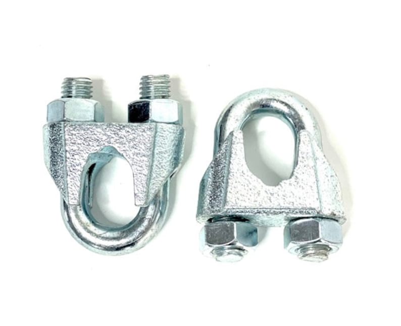 May include: Two silver metal cable clamps with a U-shaped opening. The clamps have a threaded screw on each side.
