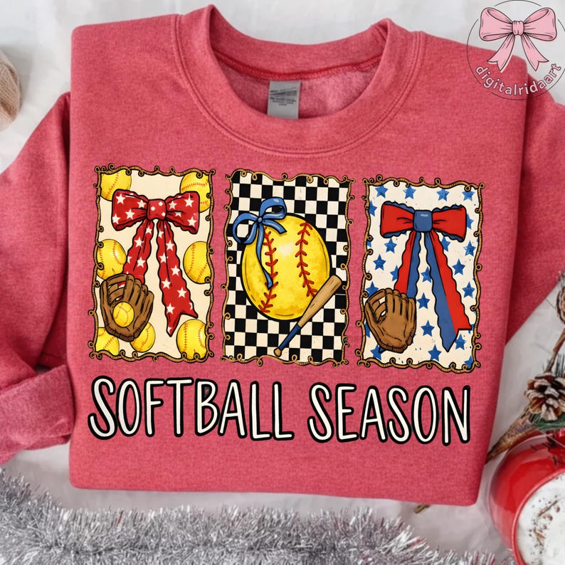 K&ouml;nnte beinhalten: Ein rotes Sweatshirt mit Softball-Motiv. Das Design umfasst Softb&auml;lle, Handschuhe und Schleifen. Die Worte "SOFTBALL SEASON" sind wei&szlig; auf der Unterseite des Sweatshirts aufgedruckt.