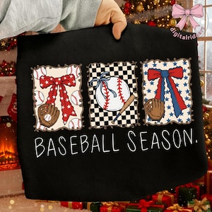 May include: Black tote bag featuring three baseball-themed designs. The designs include baseballs, gloves, and bows in red, white, and blue. The text "BASEBALL SEASON" is written in white script across the bottom.