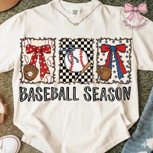 May include: White t-shirt with a baseball theme. The shirt features three rectangular designs with baseball elements: a baseball glove, baseballs, and bows. The text "BASEBALL SEASON" is printed in large, black letters across the bottom.