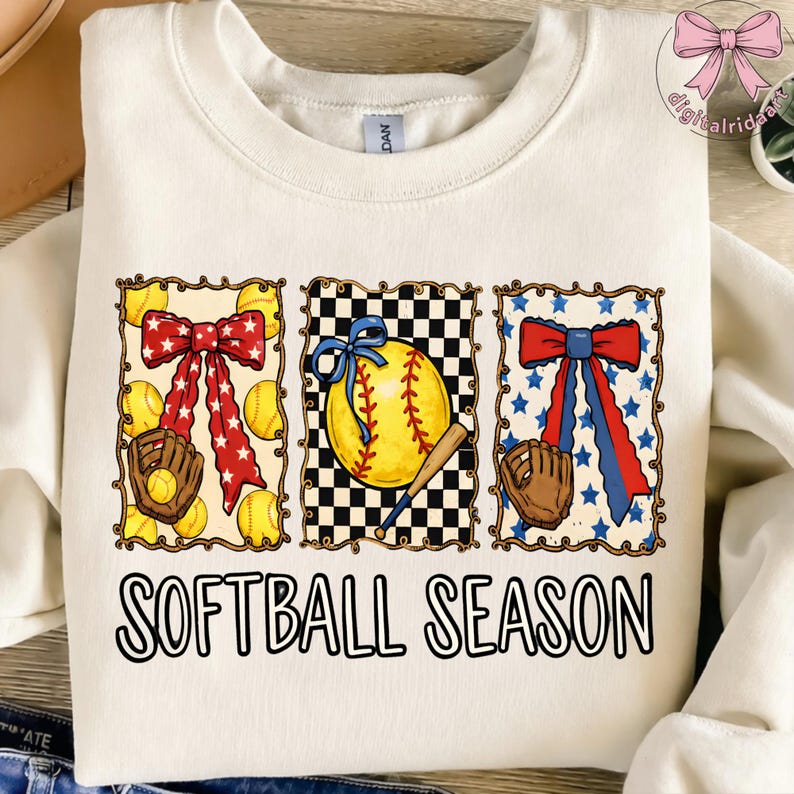 K&ouml;nnte beinhalten: Cremefarbenes Sweatshirt mit einem Softball-Motiv. Das Design umfasst drei gerahmte Bilder von Softb&auml;llen, Schleifen und Handschuhen. Der Text "SOFTBALL SEASON" ist in schwarzen Blockbuchstaben auf der Unterseite des Shirts aufgedruckt.