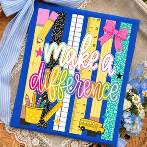 以下が含まれることがあります： 「make a difference」というカラフルな筆記体の文字が書かれた青い長方形の看板。黄色い鉛筆、白黒のノート柄、罫線入りの紙、定規、黄色いスクールバスの縦縞模様がデザインされています。