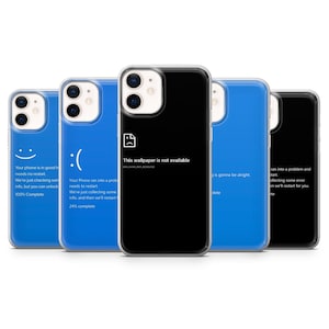 May include: Several phone cases are displayed, each with a unique design. One case is black with the text "This wallpaper is not available." Other cases are blue with a smiley face, a frowny face, and system error messages.