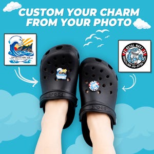 Puede incluir: Zuecos Crocs negros con abalorios personalizados. Un abalorio presenta un diseño de ola con el texto "Devils Staircase". El otro abalorio muestra un tiburón con el texto "Royal Navy Brazilian Jiu-Jitsu Team". La imagen incluye el texto "Custom Your Charm From Your Photo".