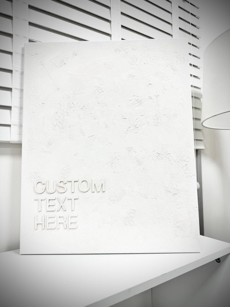 May include: A rectangular white canvas featuring a heavily textured, impasto-style surface. The lower left corner displays the embossed white text "CUSTOM TEXT HERE" in a clean, sans-serif font, creating a monochromatic and dimensional appearance.