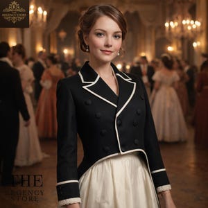 Op de afbeelding: Een zwarte jas met witte details en knopen, gedragen over een crèmekleurige jurk. De jas heeft een getailleerde pasvorm en een uniek ontwerp. Het Regency Store-logo staat linksboven en linksonder. De achtergrond toont een balzaal.