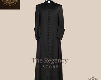 May include: A black cassock with a white collar and button-down front is displayed on a mannequin. The Regency Store logo is visible at the bottom of the image. The cassock is a long, formal garment.