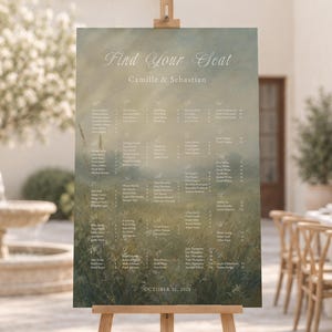 Pode incluir: Um cartaz retangular de plano de assentos para casamento com um fundo de paisagem verde e dourado com o texto Find Your Seat, Camille & Sebastian, e October 31, 2024, exibido num cavalete de tripé de madeira clara.