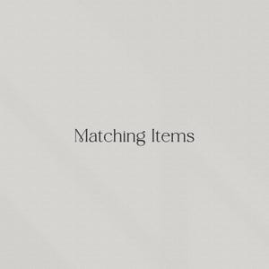 Op de afbeelding: Een lichtbeige achtergrond met de woorden "Matching Items" in een stijlvol, donker lettertype. De tekst is gecentreerd en de algehele esthetiek is minimalistisch en elegant.