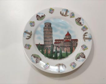 Keramisch souvenirbord met een afbeelding van de scheve toren van Pisa en de apsis van de kathedraal.