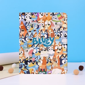 May include: A tablet case featuring a colorful collage of cartoon dogs with the word "BLUEY" in light blue. The design includes various dog characters in shades of blue, orange, and white, set against a light blue background.