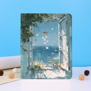 Könnte beinhalten: Eine rechteckige Tablethülle mit einem impressionistischen Gemälde eines offenen Fensters mit Blick auf das blaue Meer. Die Szene zeigt hängende Glaskugeln, grünes Blattwerk und kleine orangefarbene Fische in der Luft vor dem Himmel.