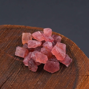Puede incluir: Una colecci&oacute;n de peque&ntilde;os fragmentos de piedras preciosas en bruto, transl&uacute;cidas y de color rojo rosado, con formas irregulares y angulosas y superficies facetadas. Las piedras muestran varios tonos de rosa intenso y coral claro.
