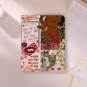 Könnte beinhalten: Eine dekorative Hülle mit einem Collage-Design. Sie zeigt eine Zeichentrickfrau, die einen Kuss gibt, Leopardenmuster, Geldscheine und den Text "BUY ME BOOKS AND CALL ME PRETTY". Goldene Kettenkanten.