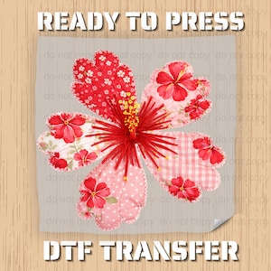 May include: A floral DTF transfer design featuring a large, stylized flower with red hibiscus blooms and a central cluster of yellow stamens. The petals are a patchwork of red and pink fabrics. The text "READY TO PRESS" and "DTF TRANSFER" are at the top and bottom.